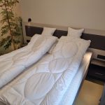 Hálószoba ággyal és éjjeliszekrénnyel a négyszemélyes apartmanban