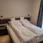 Hálószoba ággyal és éjjeliszekrénnyel a négyszemélyes apartmanban