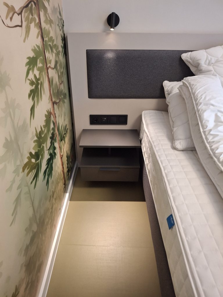 Hálószoba ággyal és éjjeliszekrénnyel a négyszemélyes apartmanban