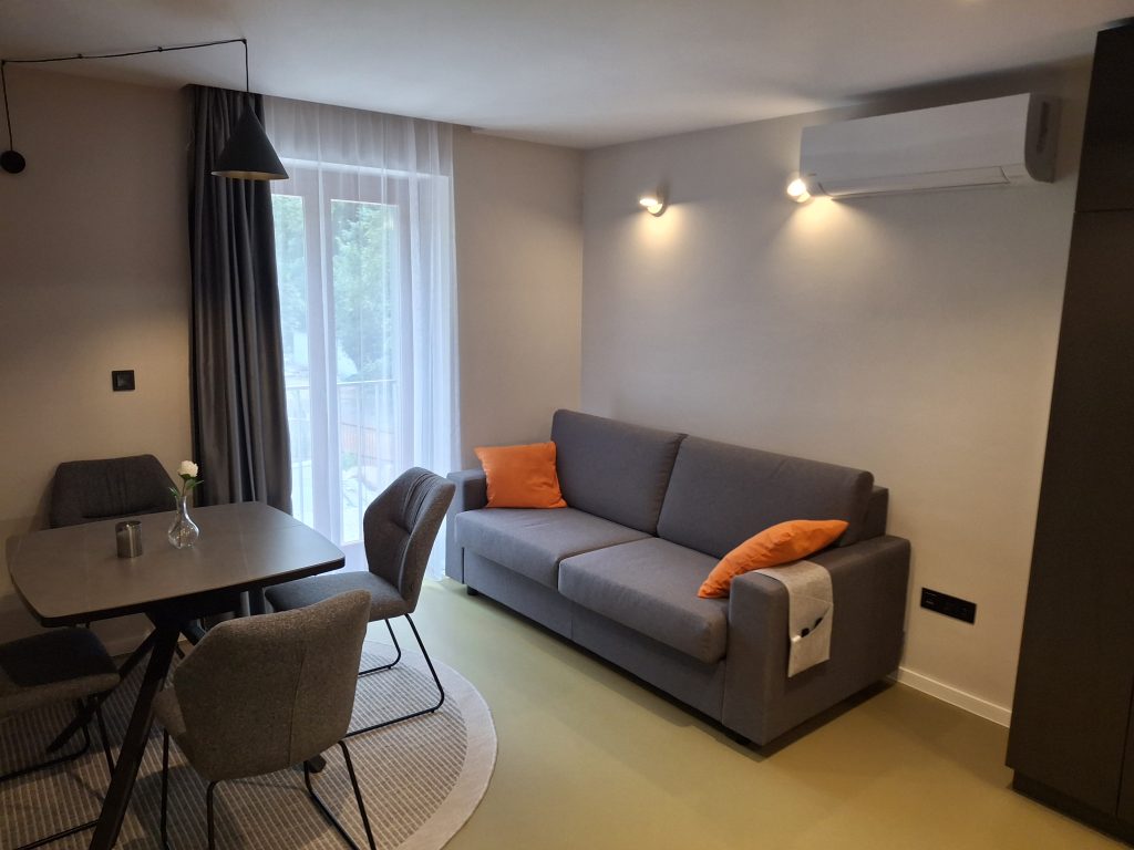 Nappali ülőgarnitúrával és étkezőasztallal a négyszemélyes apartmanban
